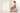 Pregnant woman seated on a lavender pregnancy ball with both feet flat on the floor, illustrating seated fit for size selection