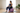 Plus-size adult seated on a lavender exercise ball with feet flat on a gray mat in a bright home studio