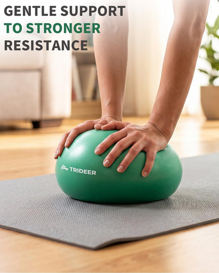 Close-up of hands pressing a green Trideer mini exercise ball on a yoga mat.