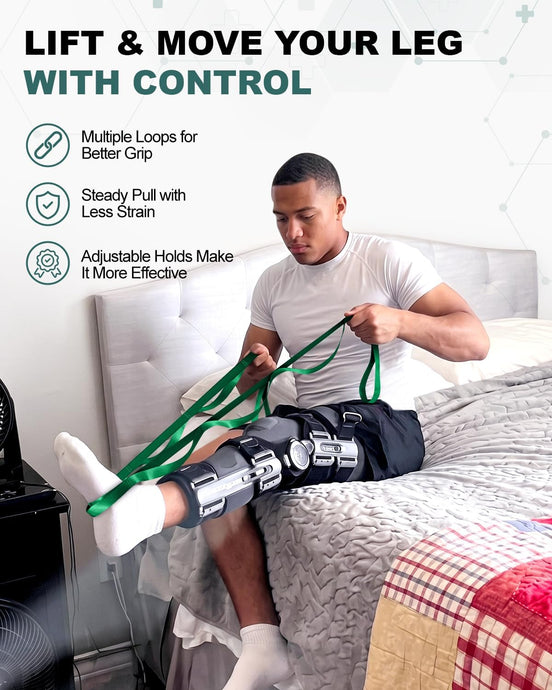 Man seated on a bed using a green multi-loop strap to lift a leg fitted with a knee brace.