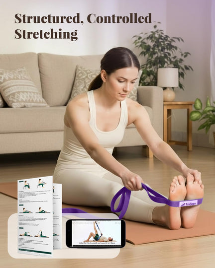 Woman using a purple stretching strap for a seated forward stretch, with a printed guide and video demonstration shown.